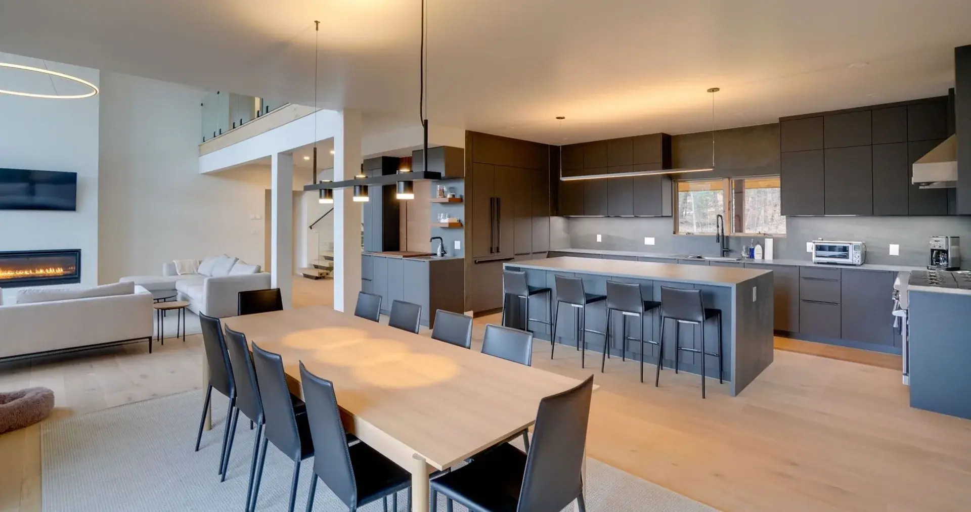 Modern open-plan kitchen with dark cabinetry designed by JMF Creative Design
